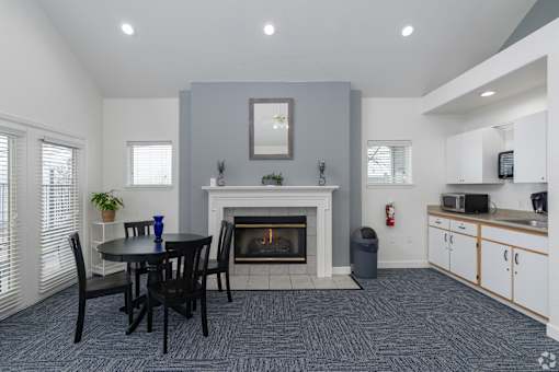 A living room with a fireplace and a dining table.