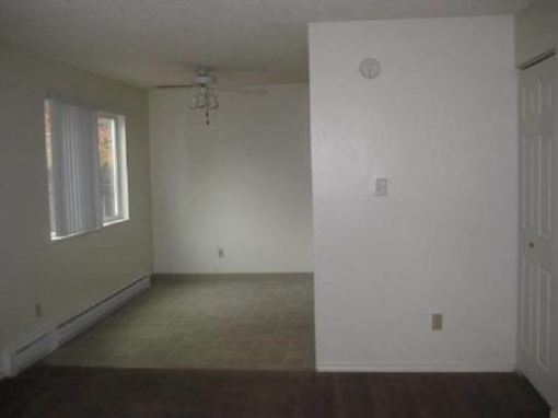 A room with a window and a ceiling fan.