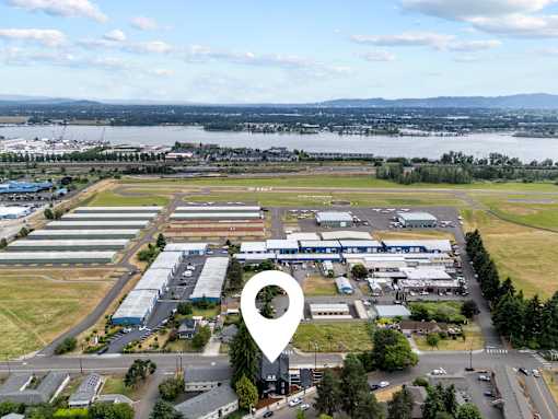 An aerial view of a large industrial area with a lake and mountains in the distance.