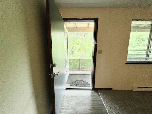 A room with a door leading to a balcony.