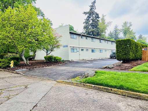 A building with a green hedge in front of it.