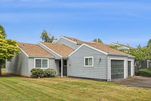 A house with a grey siding and a brown roof.
