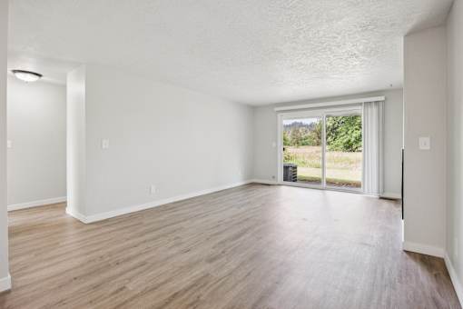 A room with a sliding glass door leading to a balcony.