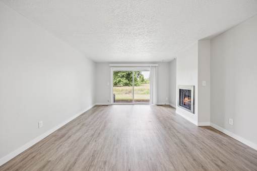 A spacious room with a fireplace and sliding glass doors.