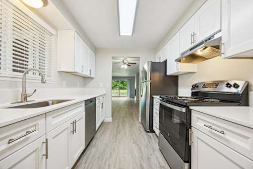 A modern kitchen with white cabinets and stainless steel appliances.