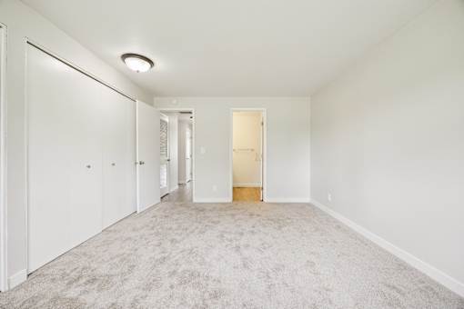 A long hallway with carpeted floors and white walls.