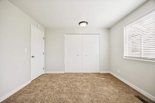 A room with carpeted floor and white walls.