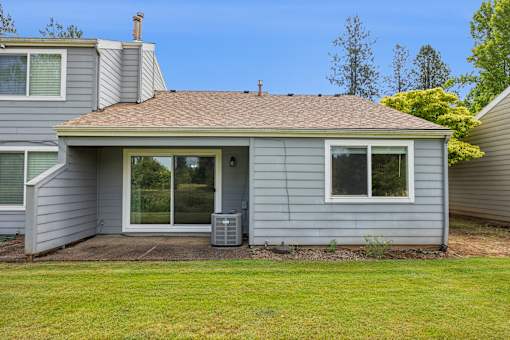 A house with a grey siding and a brown roof.