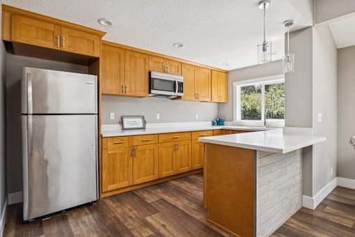 A kitchen with wooden cabinets and a white counter.