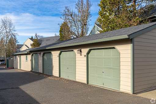 A row of garage doors in front of a house.