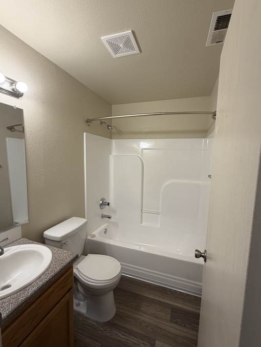 A white toilet sits next to a sink in a small bathroom.