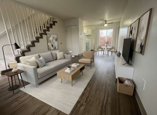 A living room with a grey couch and a wooden floor.