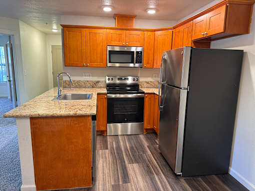 A kitchen with a black refrigerator, stove, and oven.