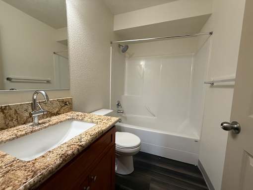 A bathroom with a sink, toilet, and bathtub.