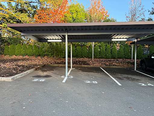 A parking lot with a canopy and a car parked under it.