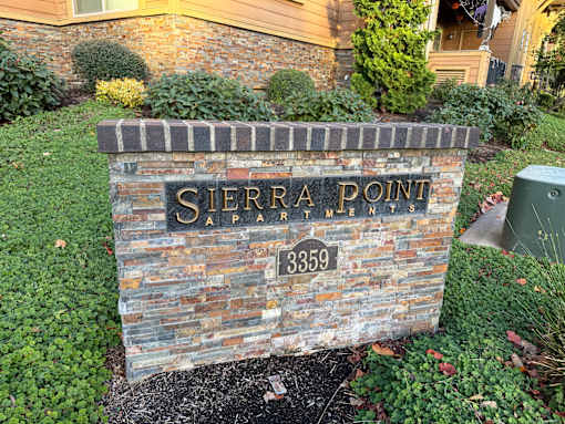 A sign that says Sierra Point OAPartment in front of a building.