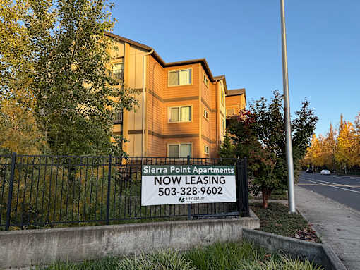 A sign for Sierra Point Apartments is displayed in front of a building.