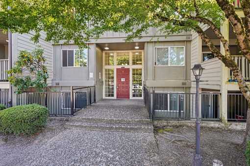 A building with a red door is surrounded by a black fence.