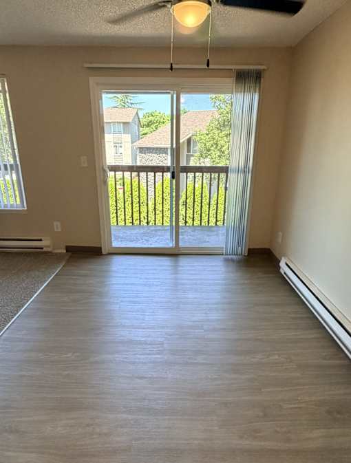 A room with a sliding glass door leading to a balcony.