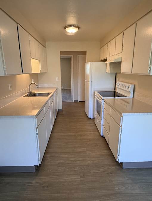 A kitchen with white appliances and cabinets.