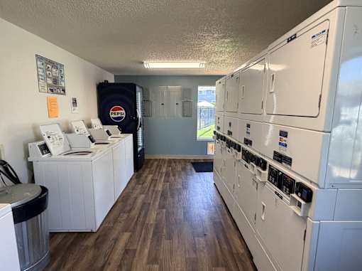 A room with a Pepsi bag and a wall of washing machines.