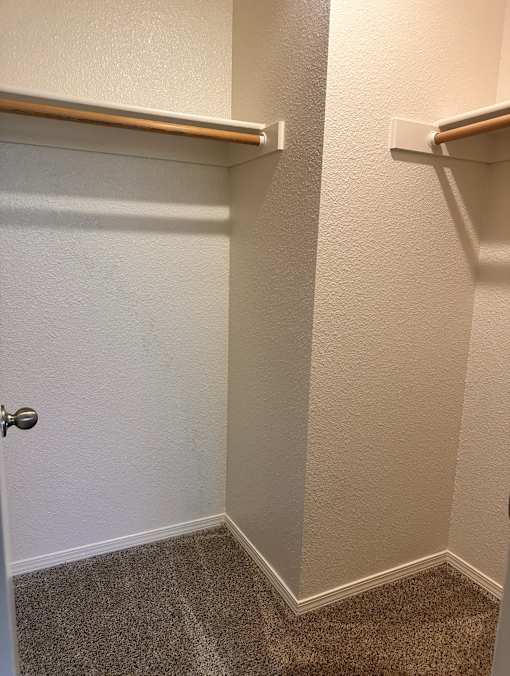 A white door with a brown handle is in a room with white walls.