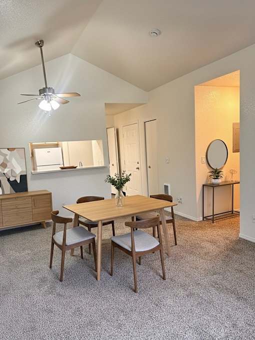 A dining room with a wooden table and chairs.