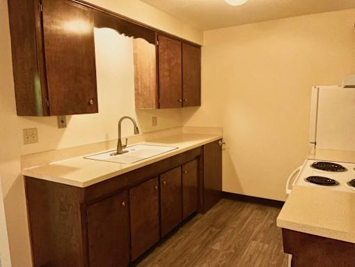 A kitchen with brown cabinets and a white countertop.