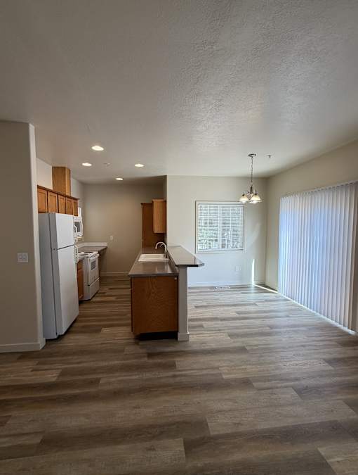 A kitchen with a refrigerator, dishwasher, and sink.