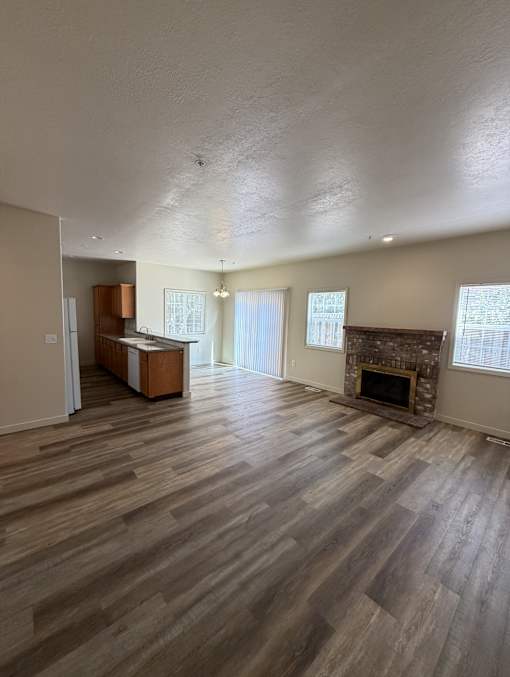 A room with a fireplace and wooden floors.