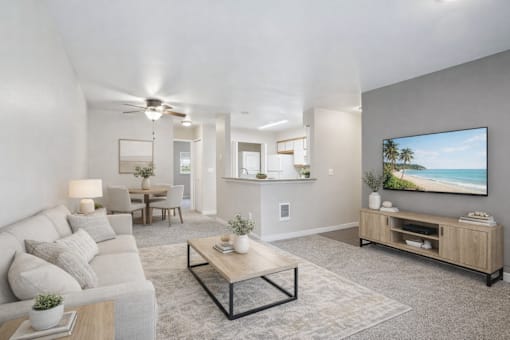 A modern living room with a grey sofa, a wooden coffee table, and a large painting on the wall.