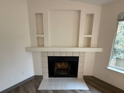 A fireplace with a white mantle and shelves above it.