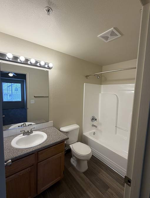 A bathroom with a sink, toilet, and bathtub.