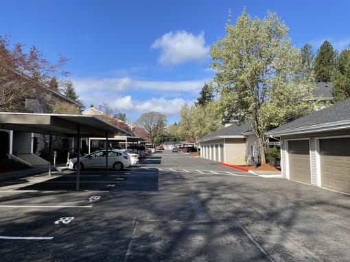 a parking lot in front of a house with a blue sky in the background