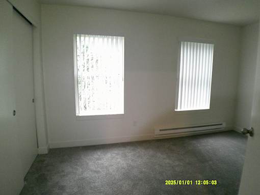 A room with a window and a radiator on the wall.