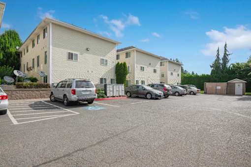A parking lot with cars and a building in the background.
