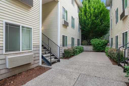 A concrete walkway leads between two apartment buildings.