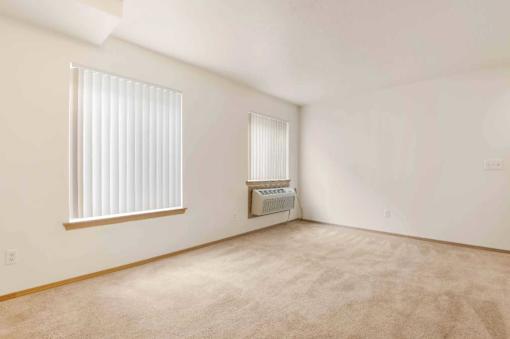 A room with a window and a wall-mounted air conditioner unit.