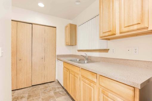 A kitchen with wooden cabinets and a sink.