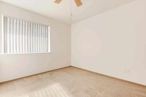 A room with a window and a ceiling fan.