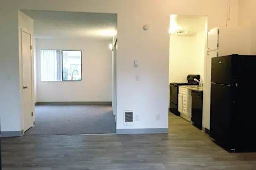 A kitchen area with black appliances and white cabinets.
