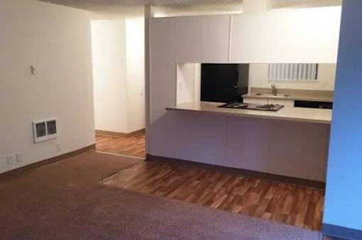 A kitchen with white cabinets and a dark countertop.