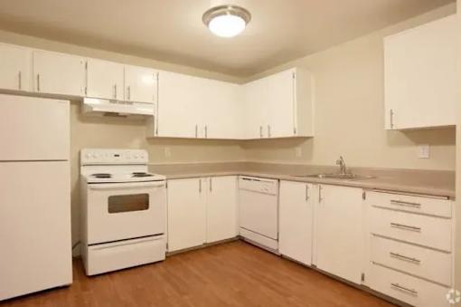 A kitchen with white appliances and cabinets.