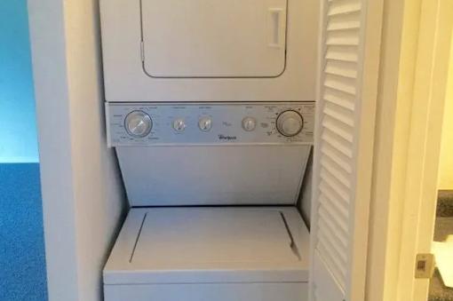 A white oven with four knobs is in a room.