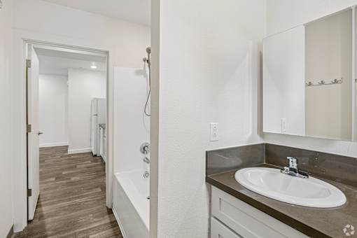 A bathroom with a white sink and a white bathtub.