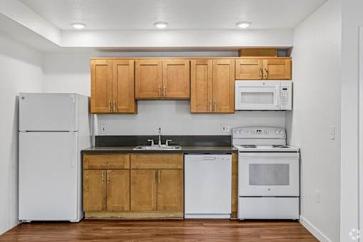 A kitchen with wooden cabinets and white appliances.