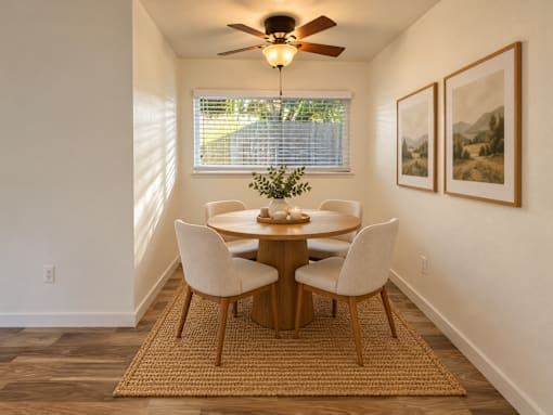 A dining room with a round table and chairs.
