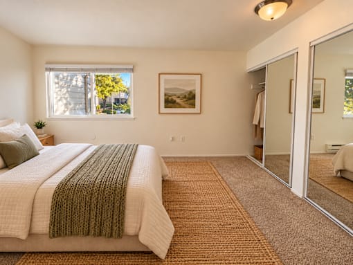 A bedroom with a large bed and a carpeted floor.