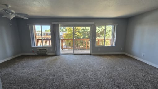 an empty living room with sliding glass doors to a balcony