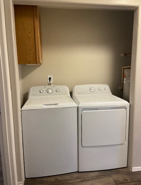 Two white washing machines in a small laundry room.